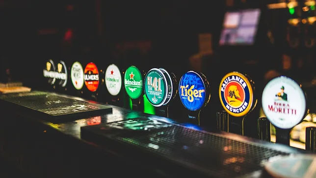 Une rangée de tireuses à bière allumées sur le comptoir du bar